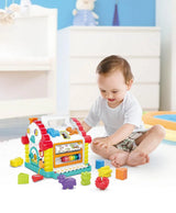 Baby playing with activity learning house toy with shape blocks and music keys in a bright indoor setting