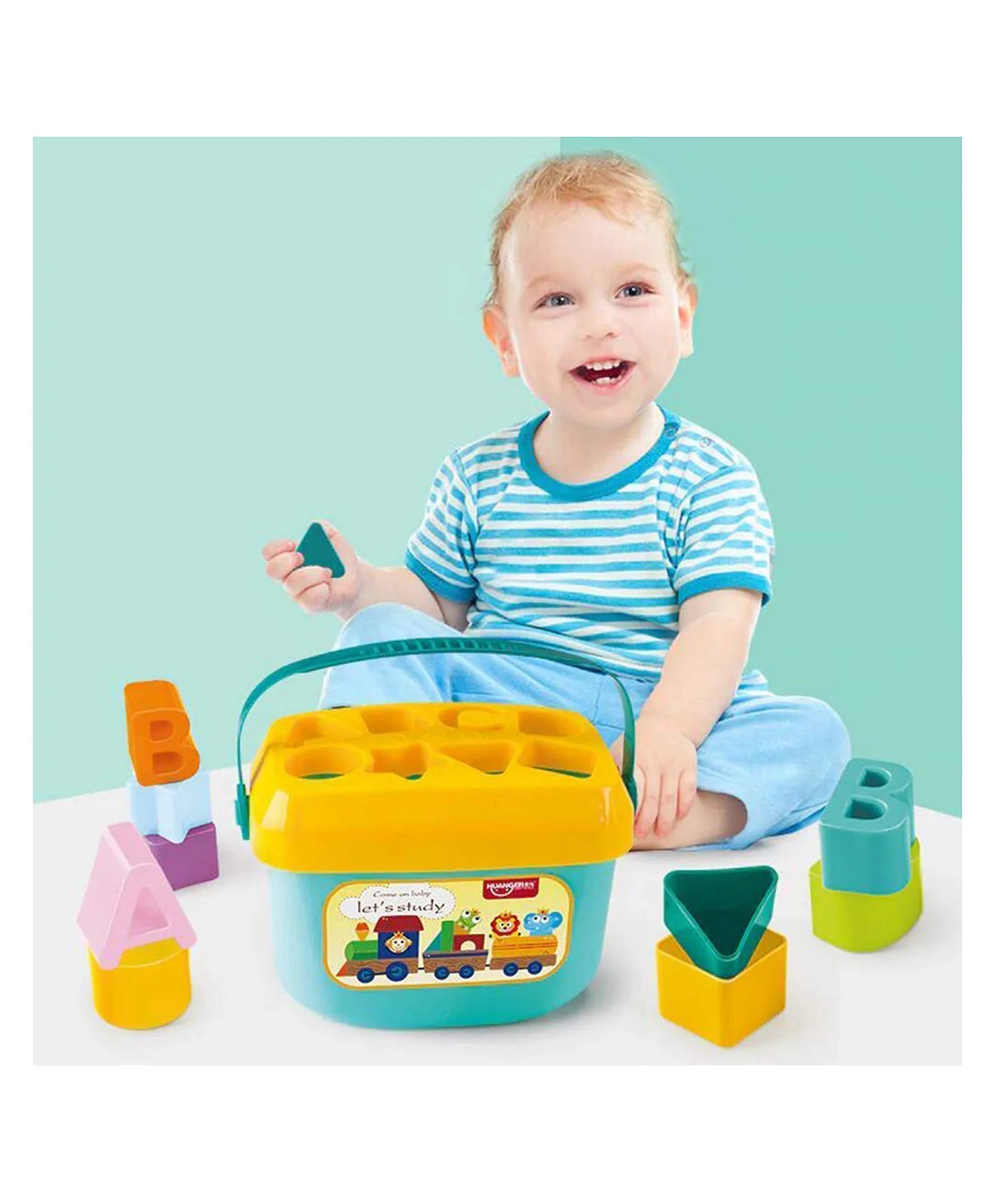 Smiling toddler playing with early learning letter shape sorting bucket and colorful ABC blocks
