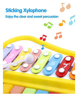 Close view of baby musical xylophone piano toy being struck with a mallet, showing colorful bars and playful music notes